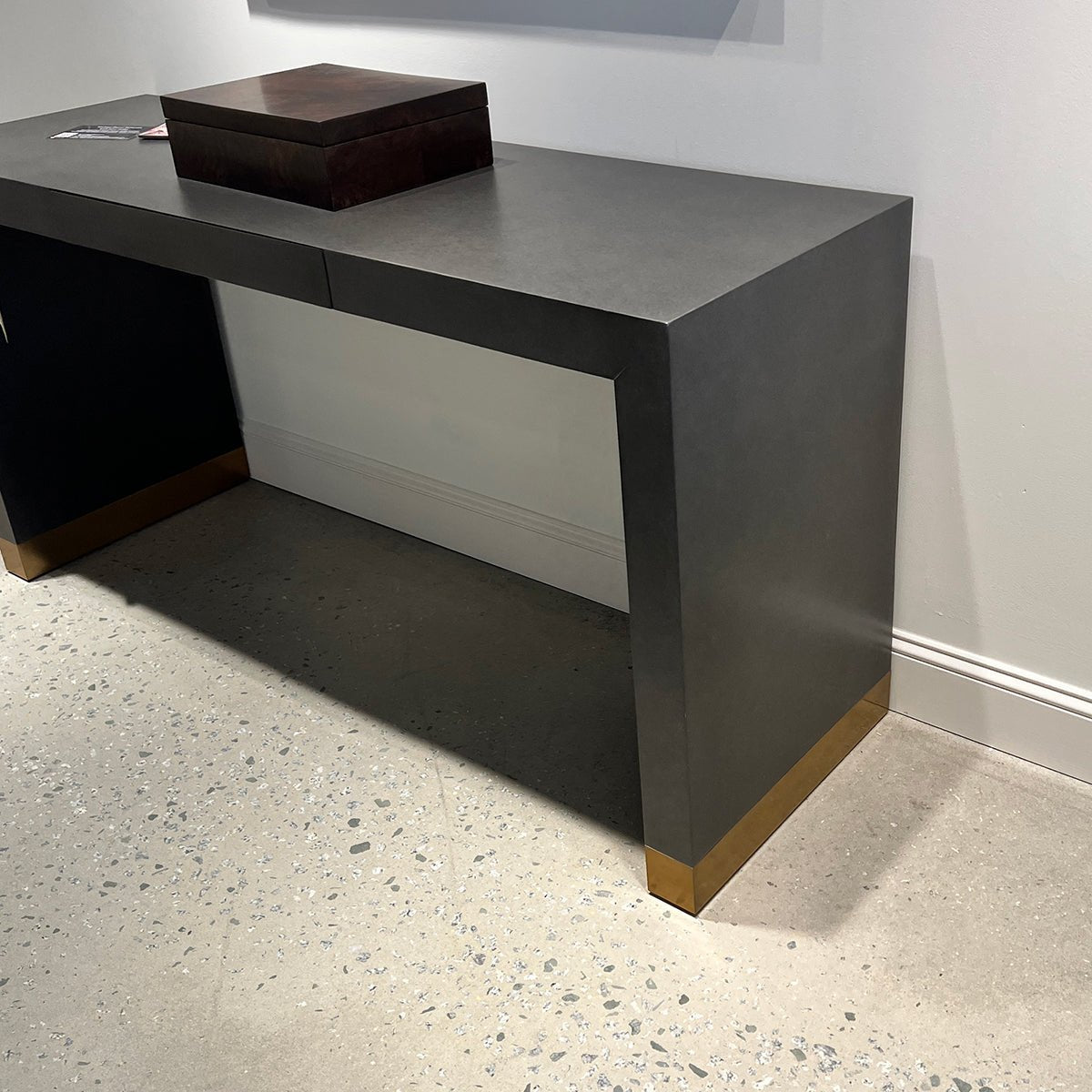 Close-up of console table corner, concrete floor detail.