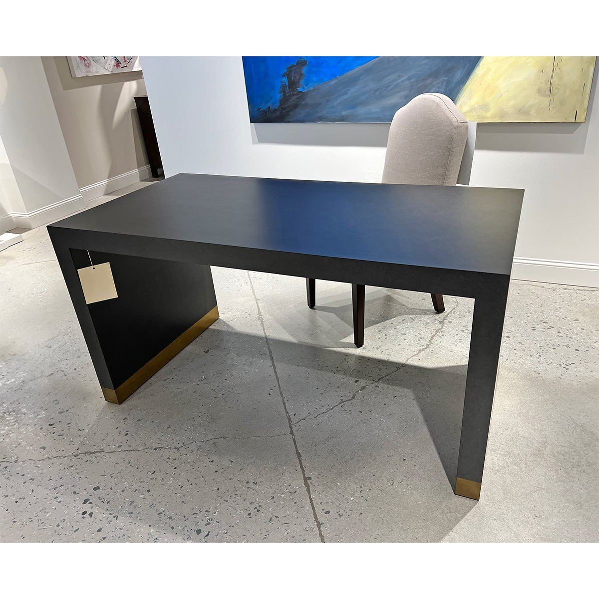 Charcoal desk in showroom with chair, modern design.