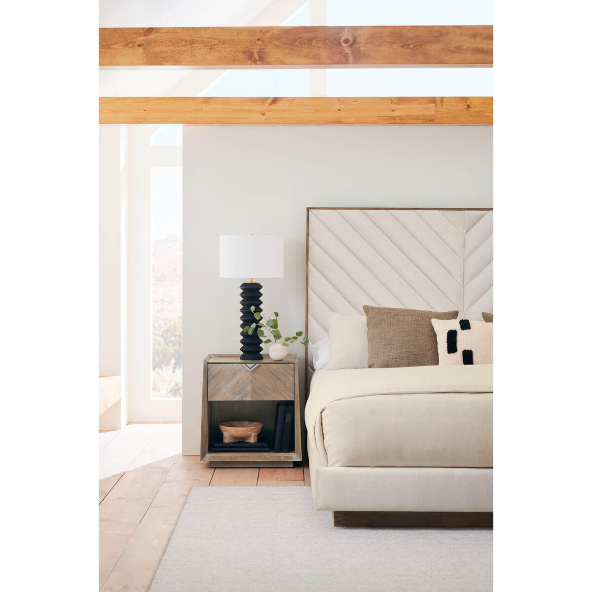 Side view of chevron tufted upholstered queen bed setup.