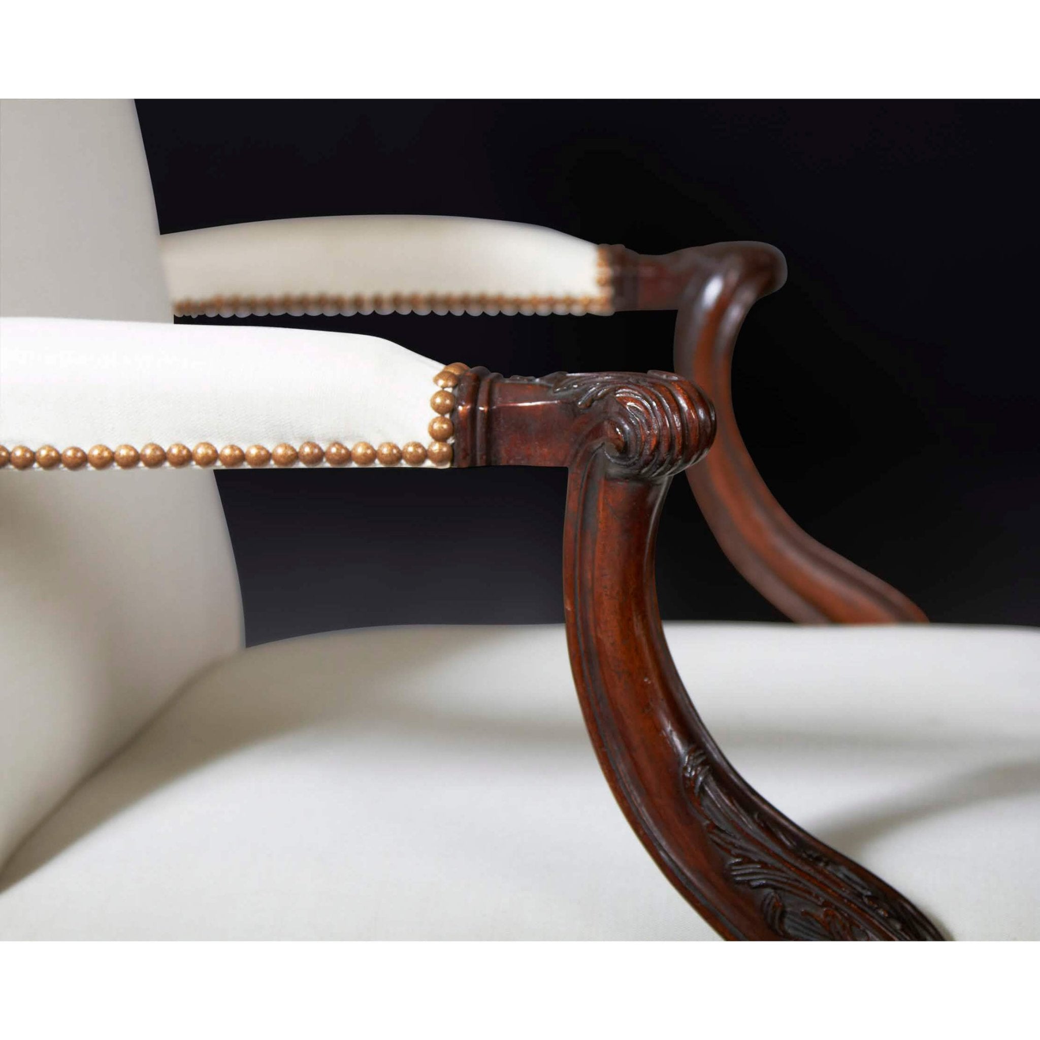 Detailed view of Chippendale Gainsborough armchair armrest and studs.