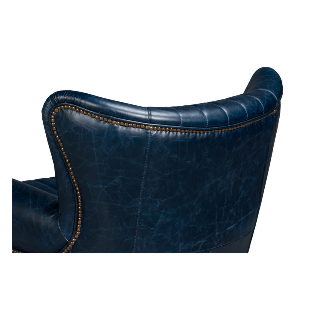 Blue leather swivel chair, back curve detail, nailhead trim.