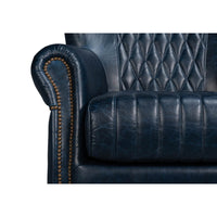 Blue leather swivel chair, close-up, armrest and seat stitching.