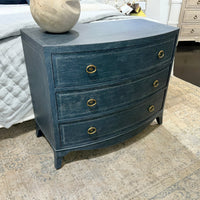 Blue chest in bedroom setting with textured area rug.