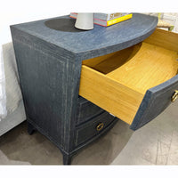 Open drawer of blue painted bedside chest with wood interior.