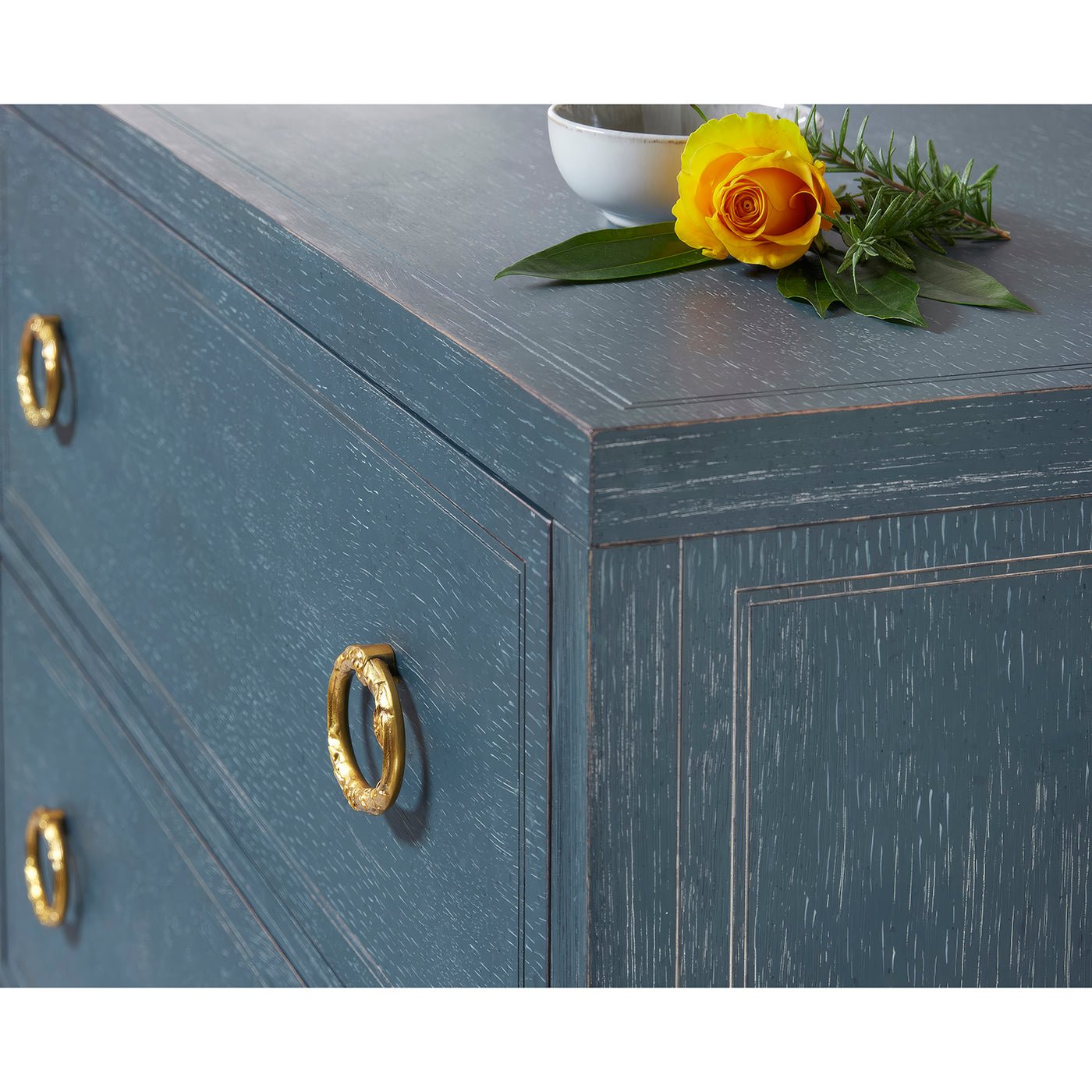 Close-up of dresser corner showing drawer handles and flower.