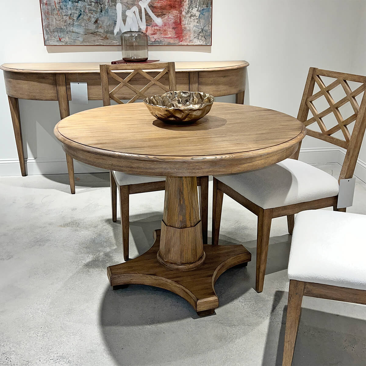 Center table and chairs in showroom, decorative bowl on top.