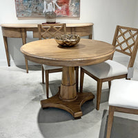 Center table and chairs in showroom, decorative bowl on top.