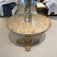 Center table with decorative vase in showroom setting.