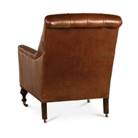 Back view of leather tufted club chair, wooden legs.