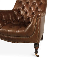 Close-up tufted leather club chair armrest, nailhead trim.