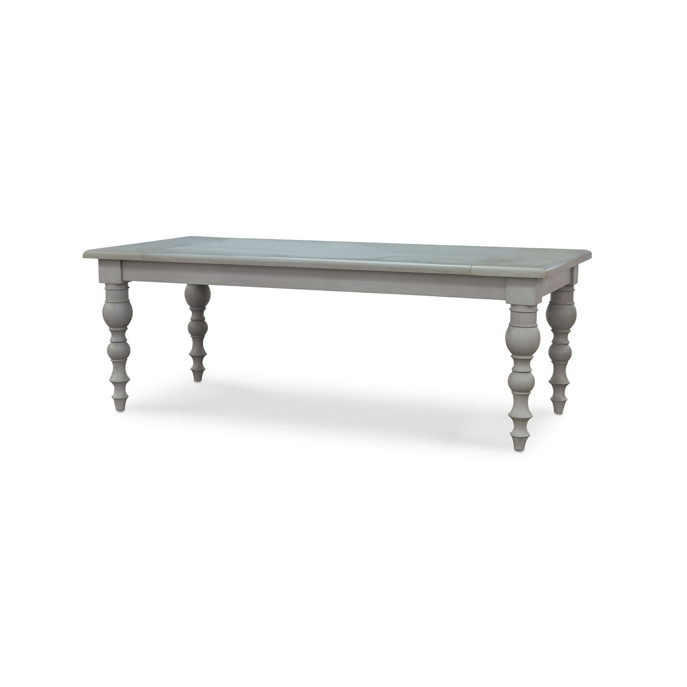 Angled view of grey farmhouse dining table, carved legs.