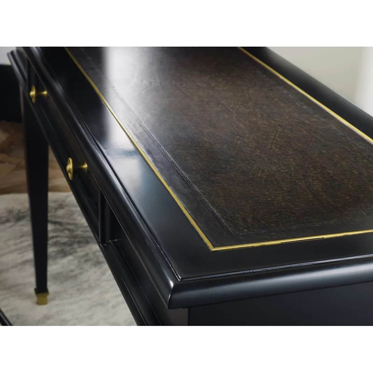 Close-up of black desk detailing and gold trim.