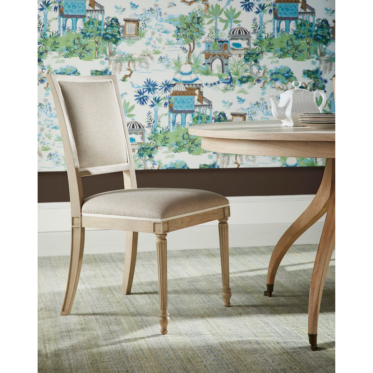 Classic French dining chair next to round dining table.