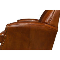 Side close-up of brown leather armchair arm and side.