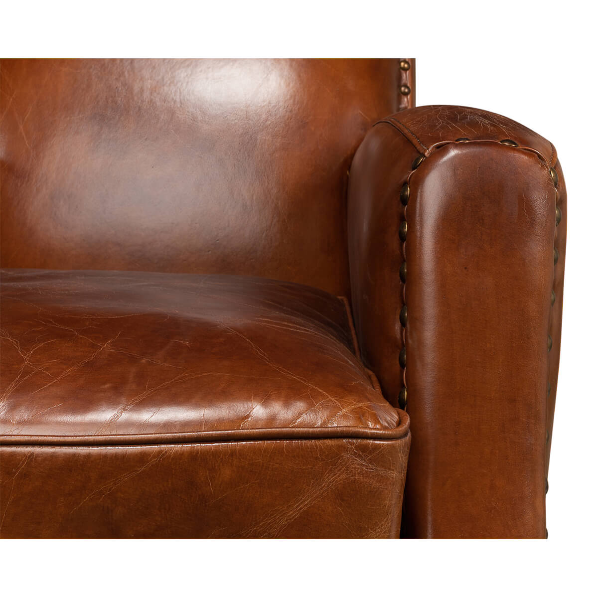 Detail of armrest on brown leather armchair.
