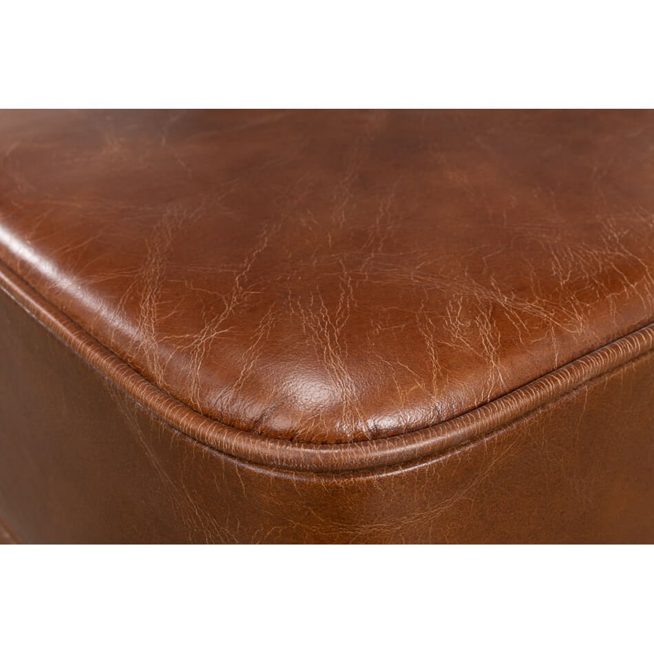 Close-up of textured leather ottoman corner detail.