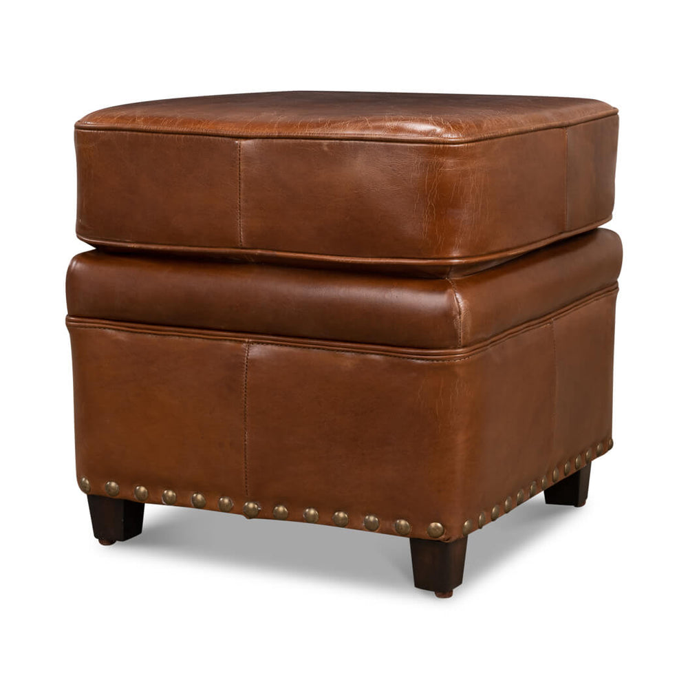 Brown leather ottoman side view with nailhead trim.