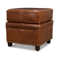 Brown leather ottoman side view with nailhead trim.