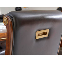 Backrest brass handle on leather tufted dining chair.