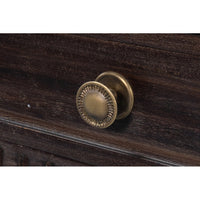 Close-up of metal drawer knob on console table.