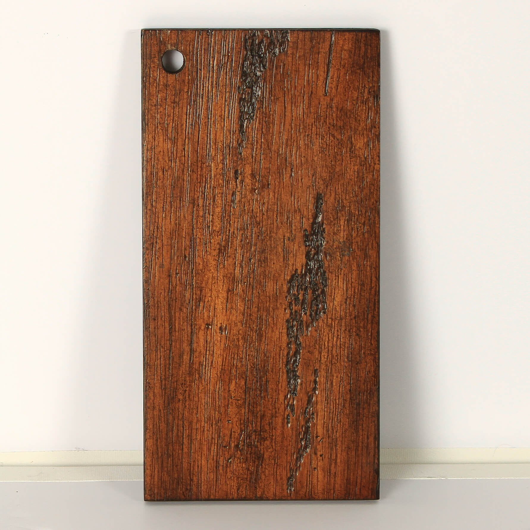 Close-up of mahogany wood texture with hole detail.