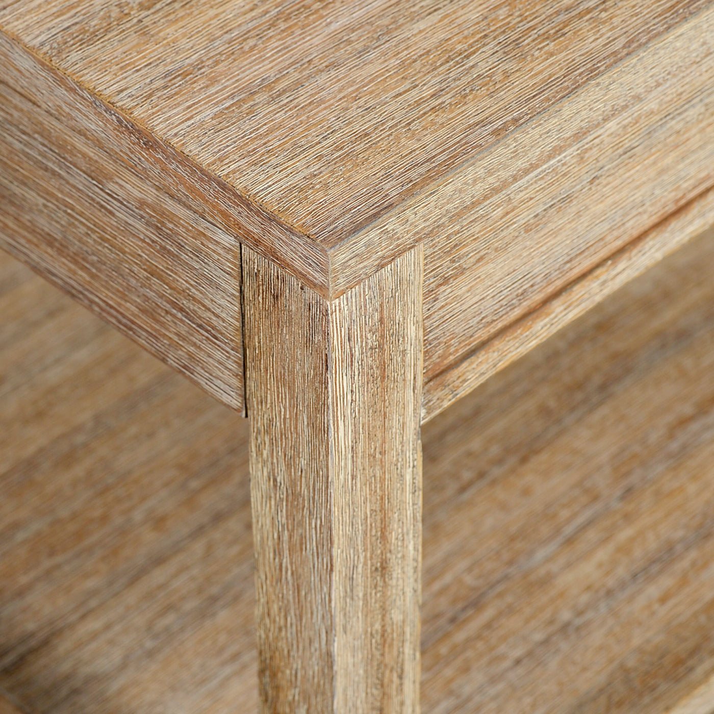 Corner detail of weathered side table, wood grain visible.