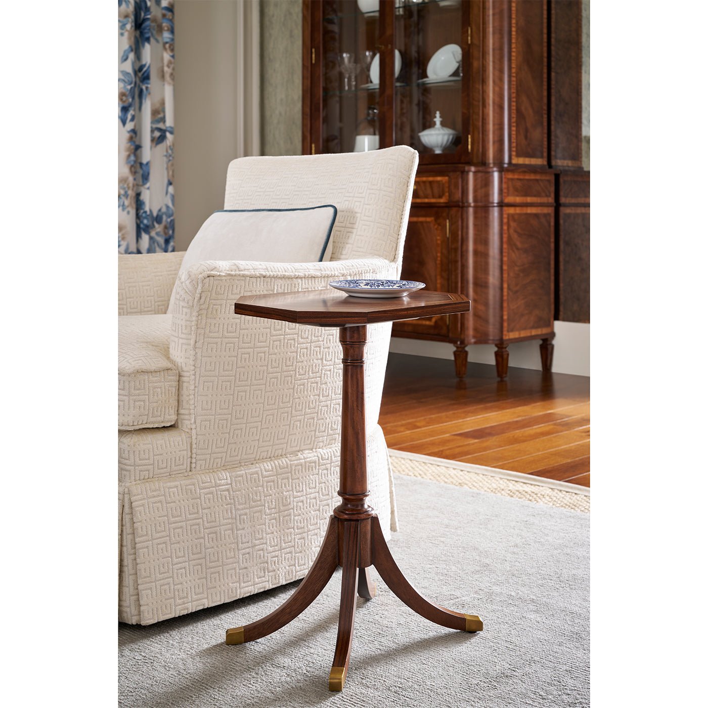Octagonal accent table beside armchair in living room.