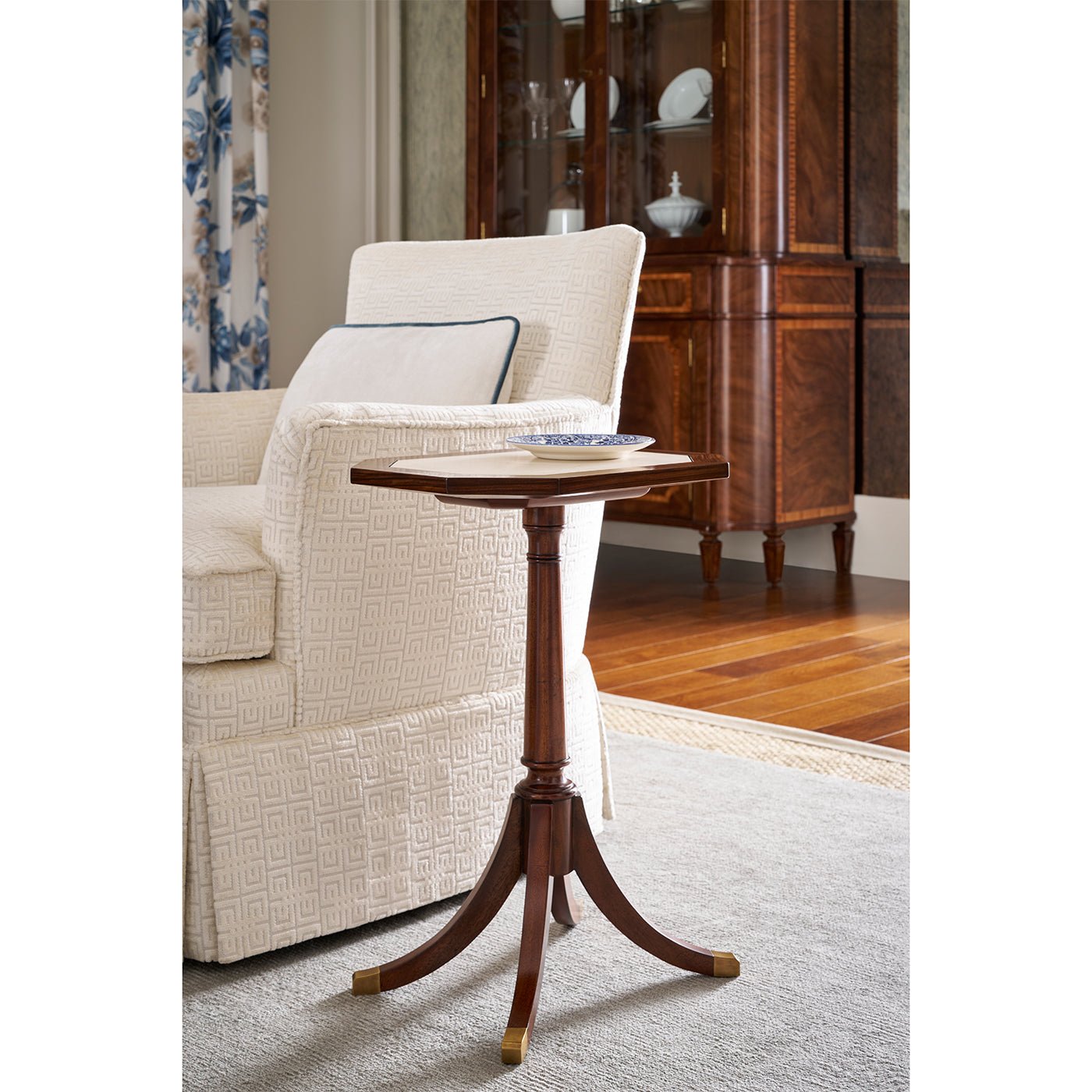 Marble top accent table beside a cream sofa.