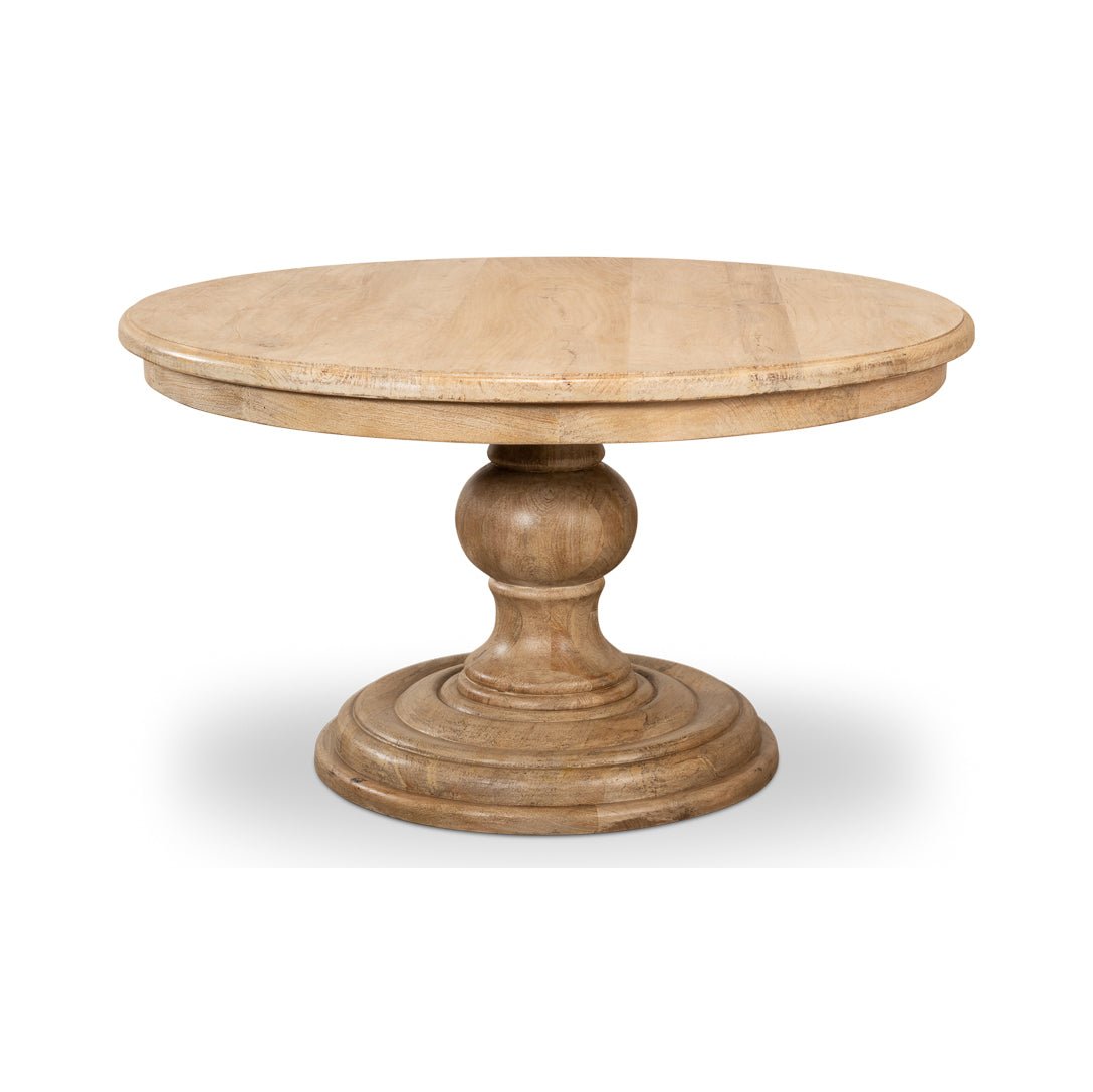 Round wooden pedestal dining table front angle view.