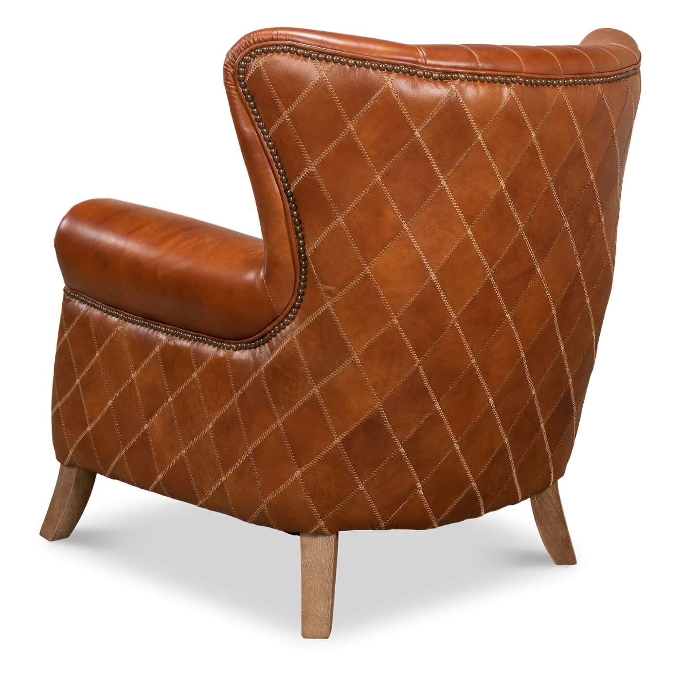 Side-back angle of quilted brown leather armchair.
