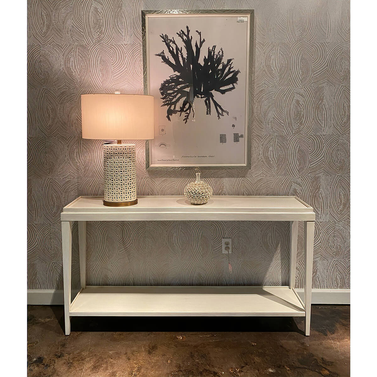 Console table styled with lamp and art in living room.