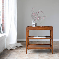 Side table with vase, styled in bright room setting.