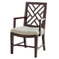 Wooden dining chair with trellis back, armrests, patterned seat.