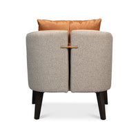 Classic tub chair rear view highlighting brass accent.