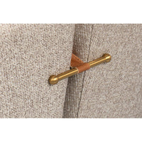 Brass accent detail on classic tub chair's back.