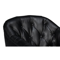 Tufted design close-up on classic black leather armchair.