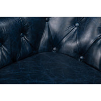 Seat and tufting detail on blue leather armchair.