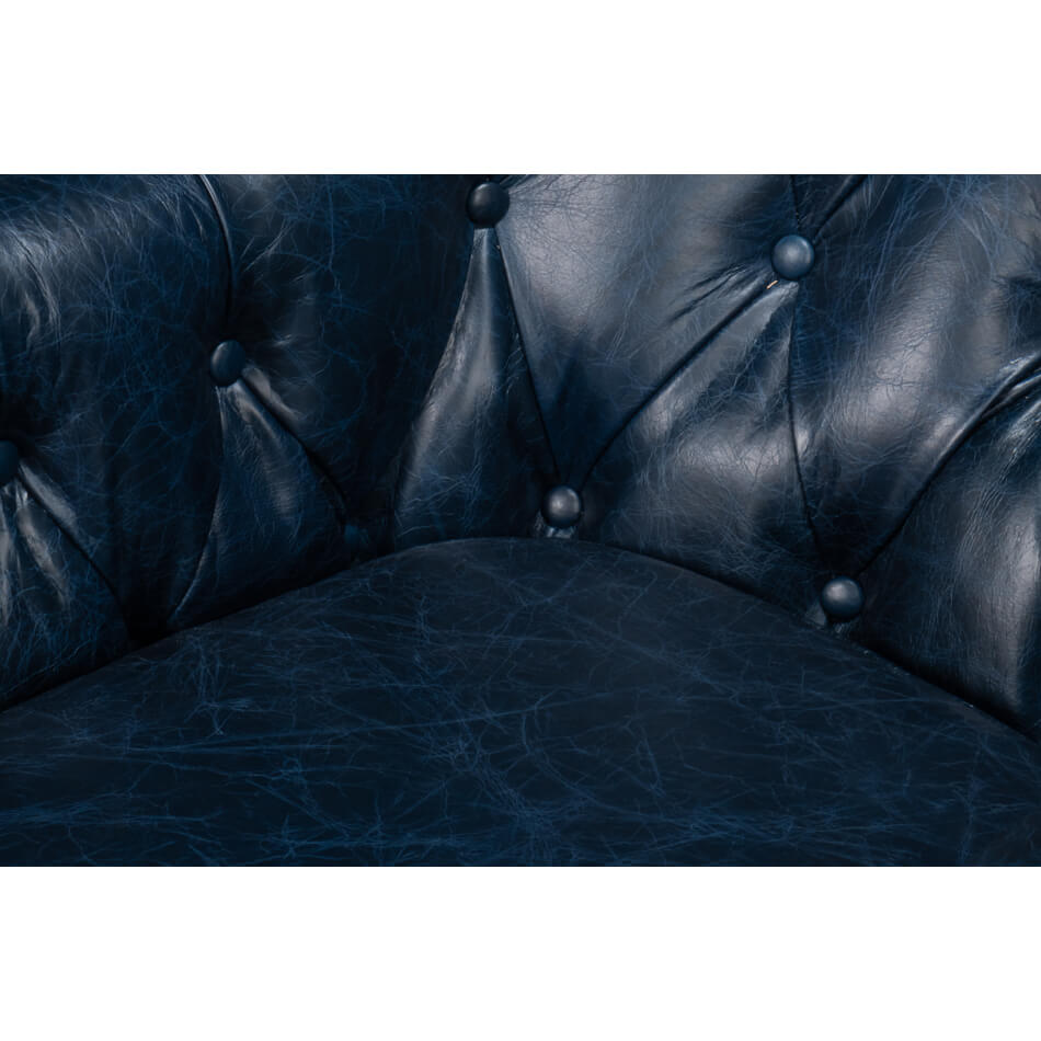 Seat and tufting detail on blue leather armchair.