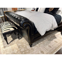 Corner detail of classic tufted leather king bed.