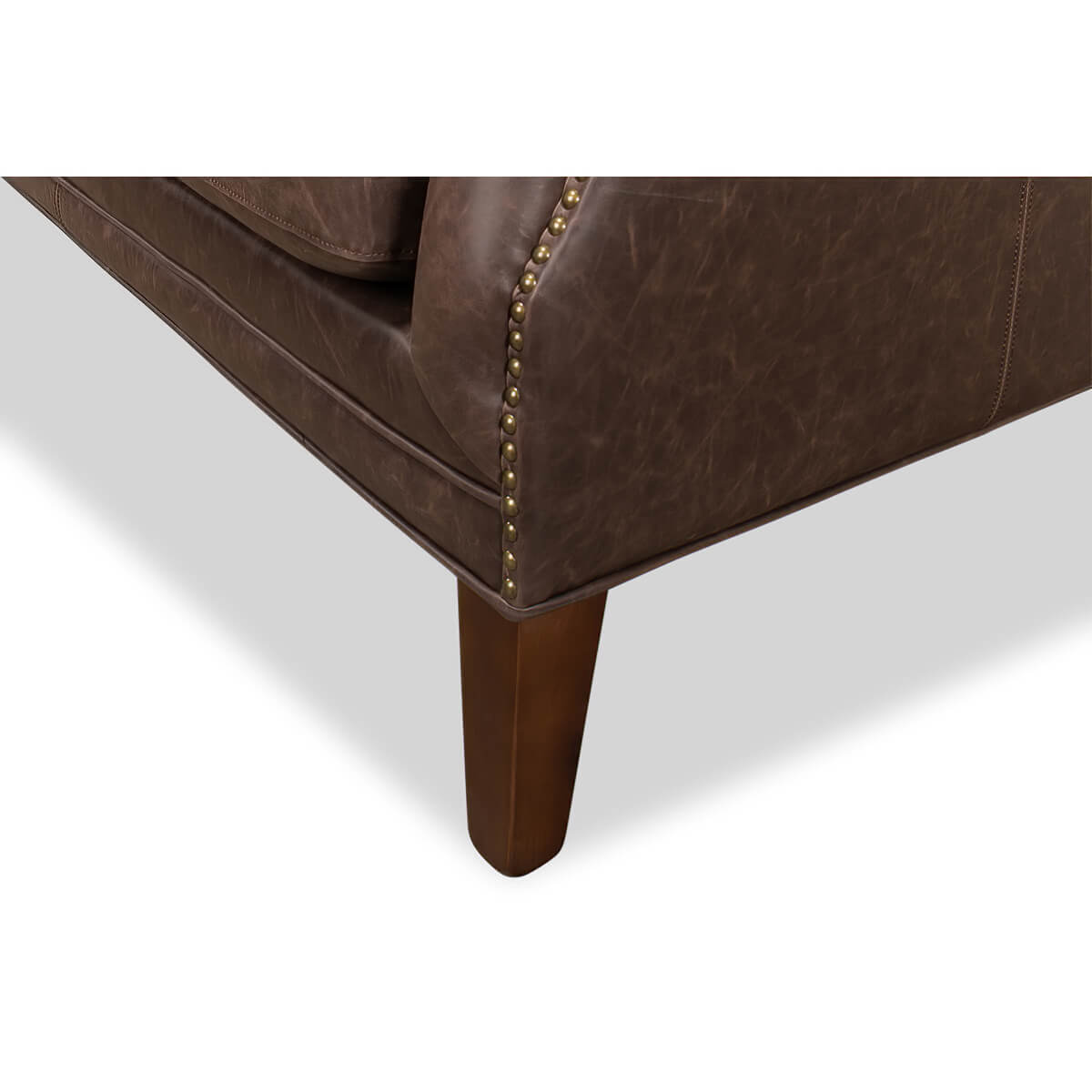 Wooden leg detail, brown tufted love seat corner.