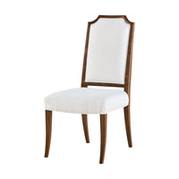 White upholstered dining chair with wooden frame, angled view.