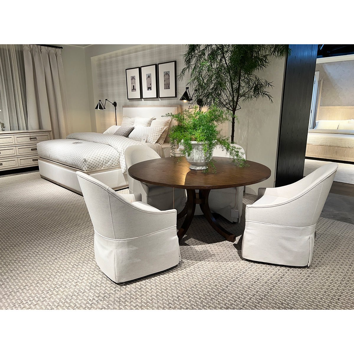 Dining room featuring white skirted chairs around wooden table.