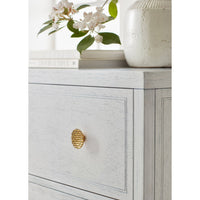 Close-up of white nightstand with decorative knob detail.