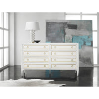 Dresser in modern room with abstract art and lamp.