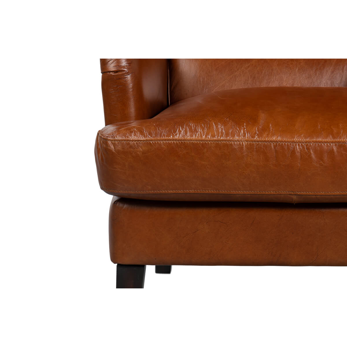 Close-up of seat cushion on leather wingback chair.