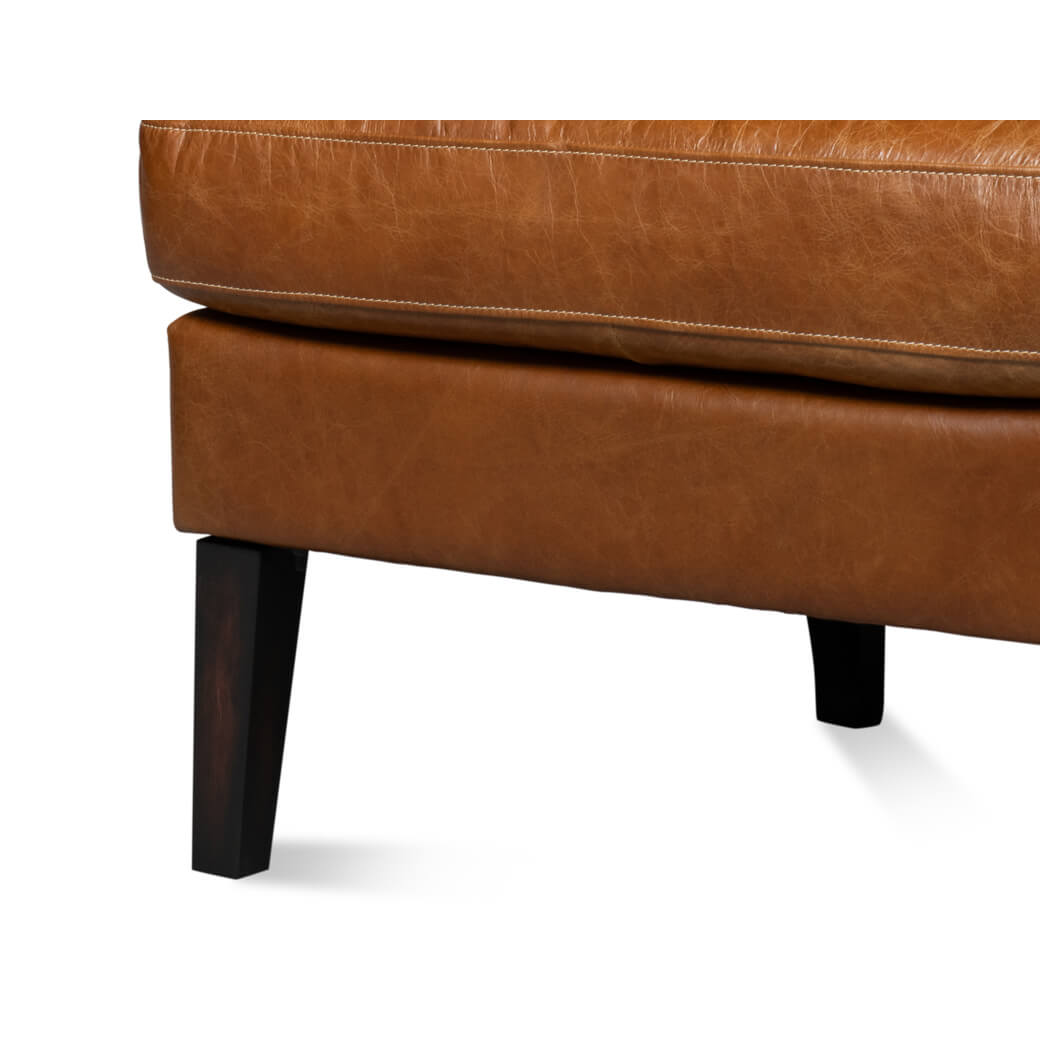 Chair leg and cushion detail on leather wingback chair.