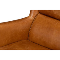 Close-up of seat and backrest of leather wingback chair.