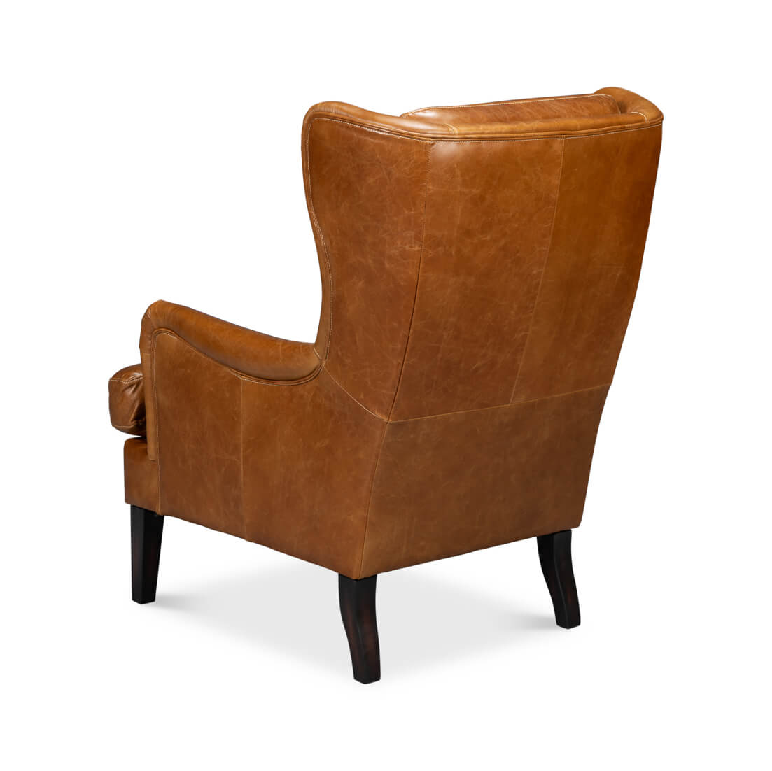 Rear angled view of brown leather wingback chair.