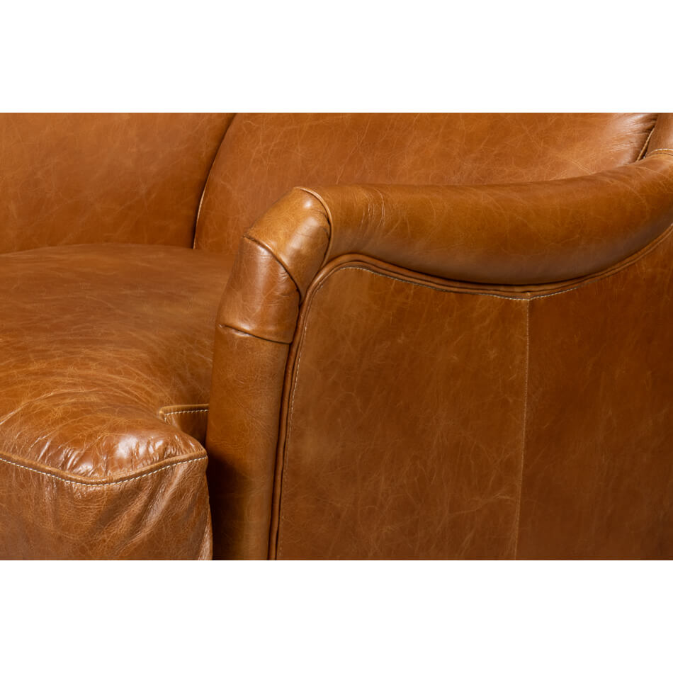 Close-up of armrest on leather wingback chair.