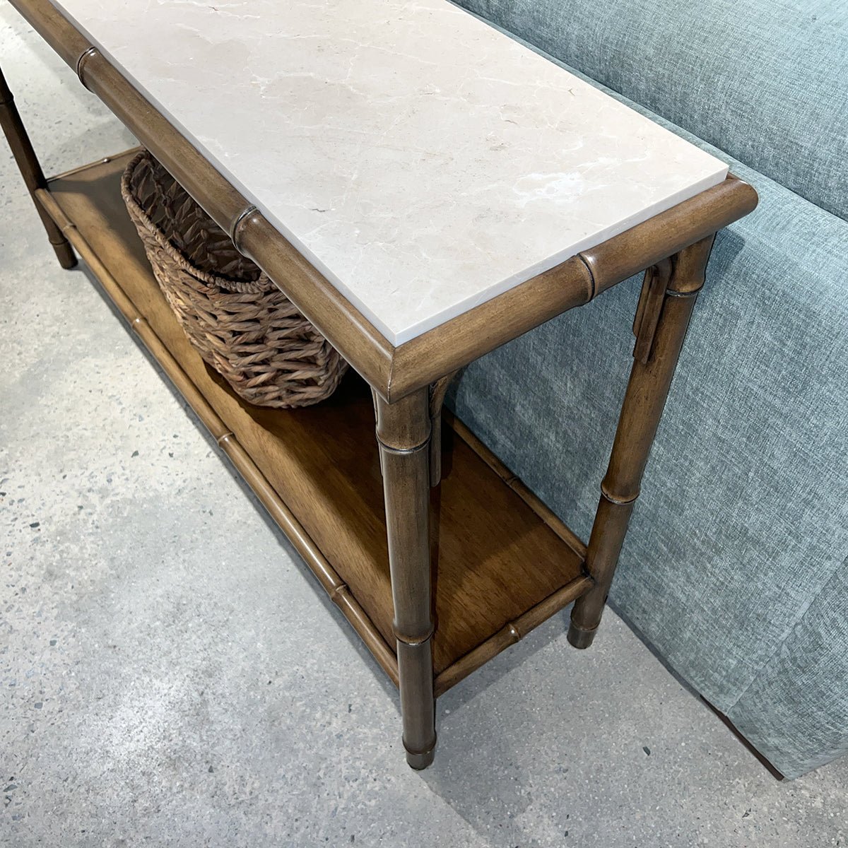 Close-up of bamboo console table, marble texture top.
